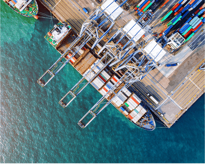 Aerial view of a bustling container port with colorful shipping containers, cargo ships, and intricate dock