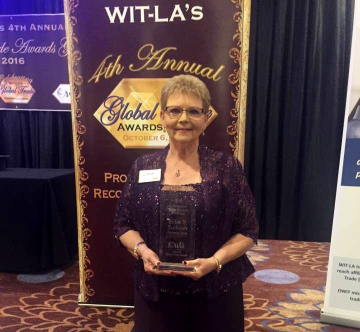Older woman in a sparkly purple dress holding an award at WIT-LA's 5th Annual Global Awards event in 2016