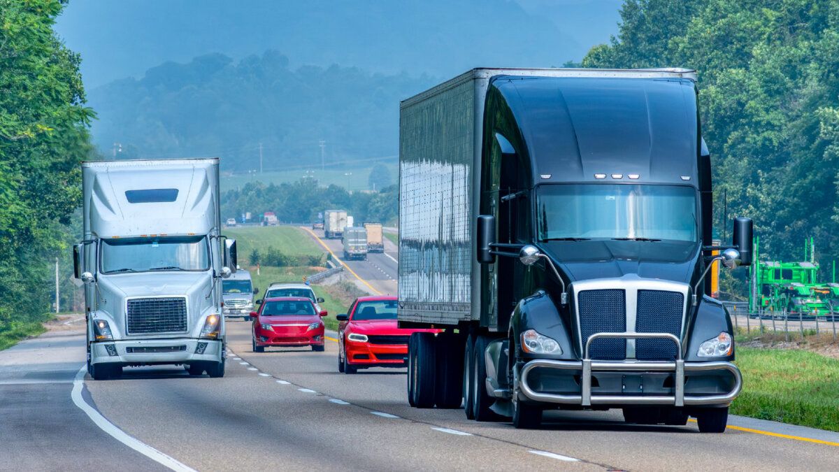 Semi trucks with trailers driving on a highway